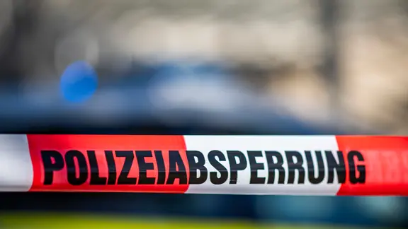 Auf einem rot-weiß-gestreiftem Band steht "Polizeiabsprerrung.