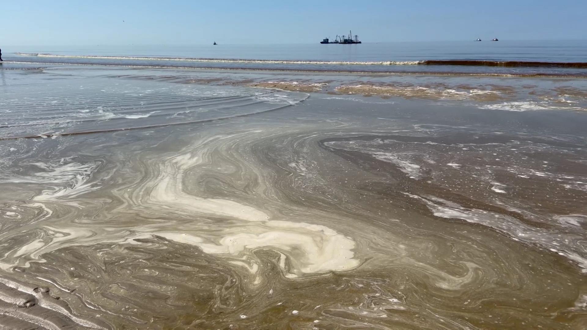 Auf dem Meerwasser am Strand hat sich Schaum gebildet. | NonstopNews