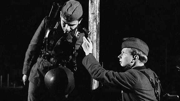 Zwei Soldaten bewachen in der Nacht die ostdeutsche Grenze