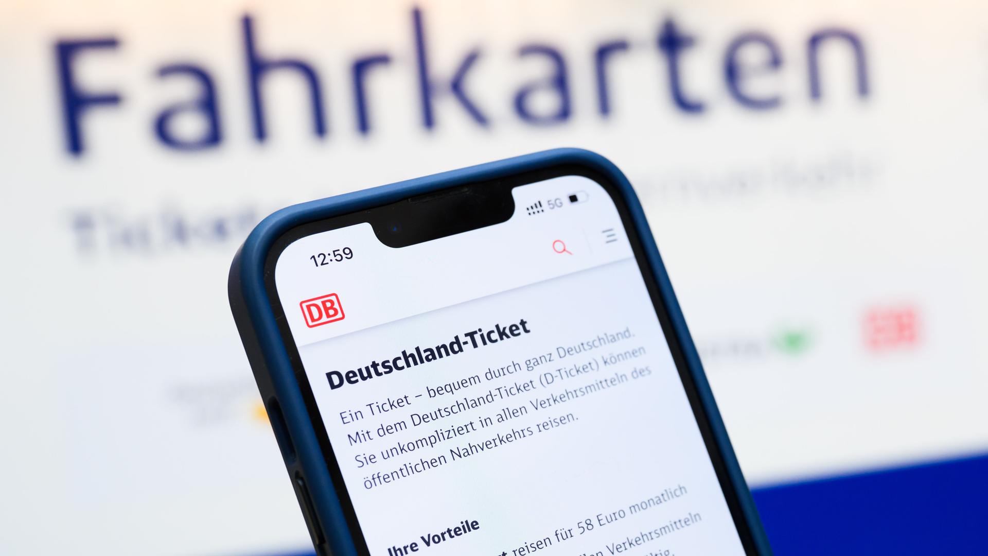 Ein Deutschlandticket wird auf einem Handy angezeigt, im Hintergrund ist ein Fahrkartenautomat. | Julian Stratenschulte, dpa picture-alliance