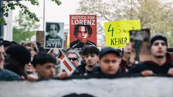 Menschen halten auf einer Demonstration für den getöteten Lorenz A. Schilder hoch.