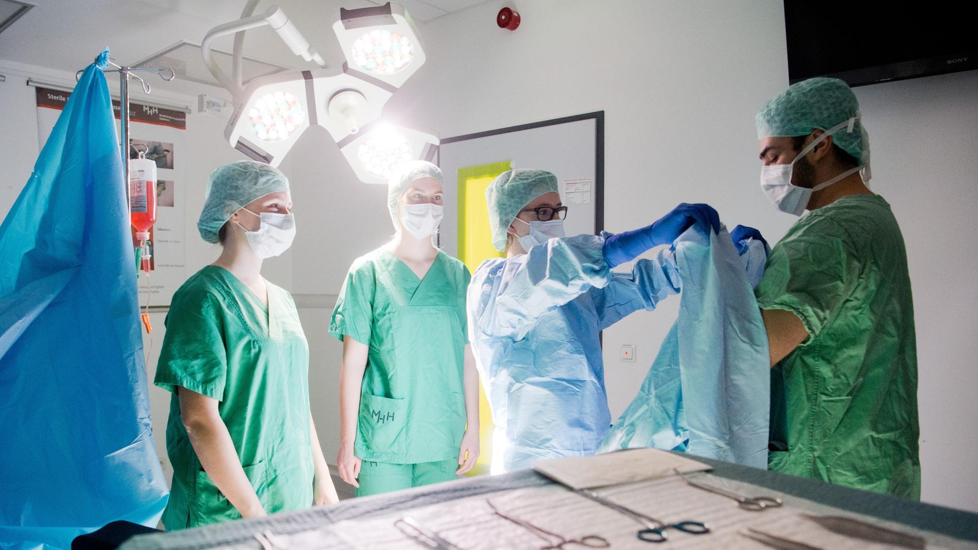Medizinstudenten üben, wie man sich unter hygienischen Aspekten in einem OP-Raum verhält (gestellte Szene). | picture alliance / dpa, Julian Stratenschulte