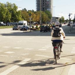 Eine Fahrradfahrerin fährt über eine Straßenkreuzung.