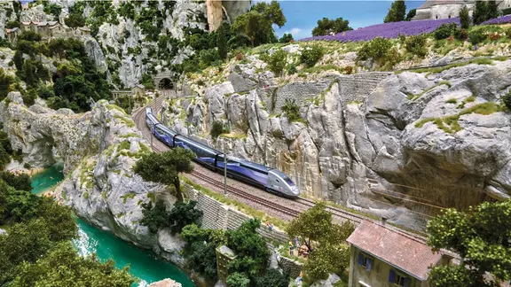 Ein TGV fährt durch eine felsige Landschaft im Abschnitt Provence des Miniatur Wunderlands.
