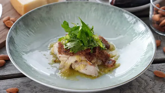 Forellenfilet mit Mandelpesto-Kruste auf einem Teller serviert | NDR, Florian Kruck Forellenfilet mit Mandelpesto-Kruste auf einem Teller serviert