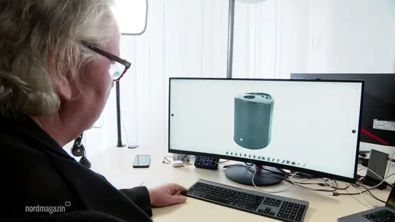 Eine Person vor einem Monitor.