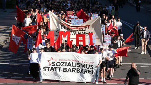 Teilnehmer halten Banner während der "revolutionären 1. Mai Demonstration". Die Demonstration hat das Motto "Eine Welt zu gewinnen".