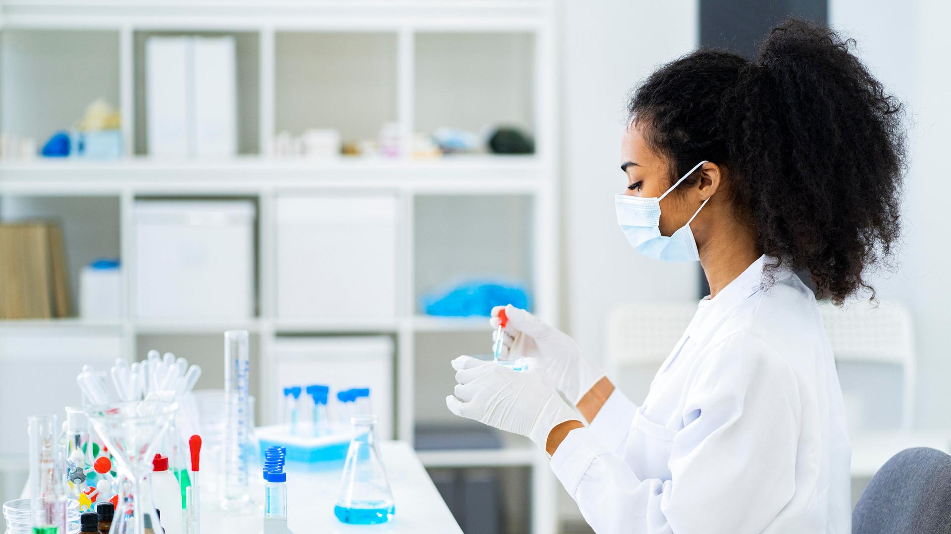 Eine Chemielaborantin hält eine Pipette und eine Petrischale in der Hand. | picture alliance / Westend61 | Giorgio Fochesato, Giorgio Fochesato