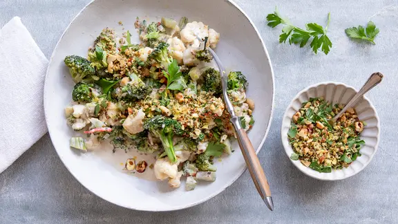 Ein Teller mit Brokkoli und Blumenkohl, daneben ein Schälchen mit einer Nuss-Gremolata.