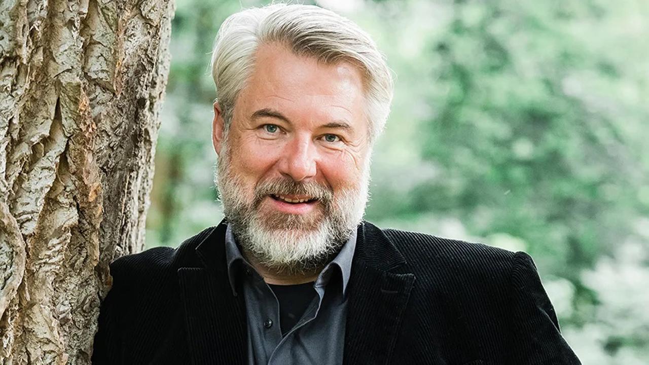 Schauspieler Dieter Fischer, an einen Baum gelehnt
