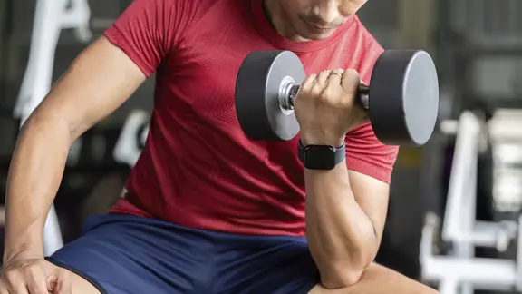 Mann macht Kraftsport mit einer Hantel.