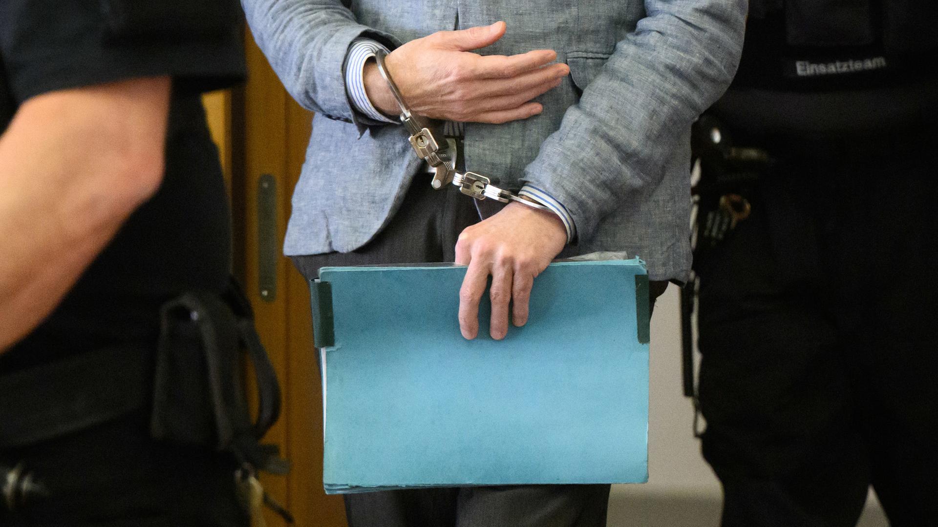 Der Angeklagte Christian B. kommt mit Handschellen in den Gerichtssaal im Landgericht Braunschweig. | picture alliance / dpa, Julian Stratenschulte