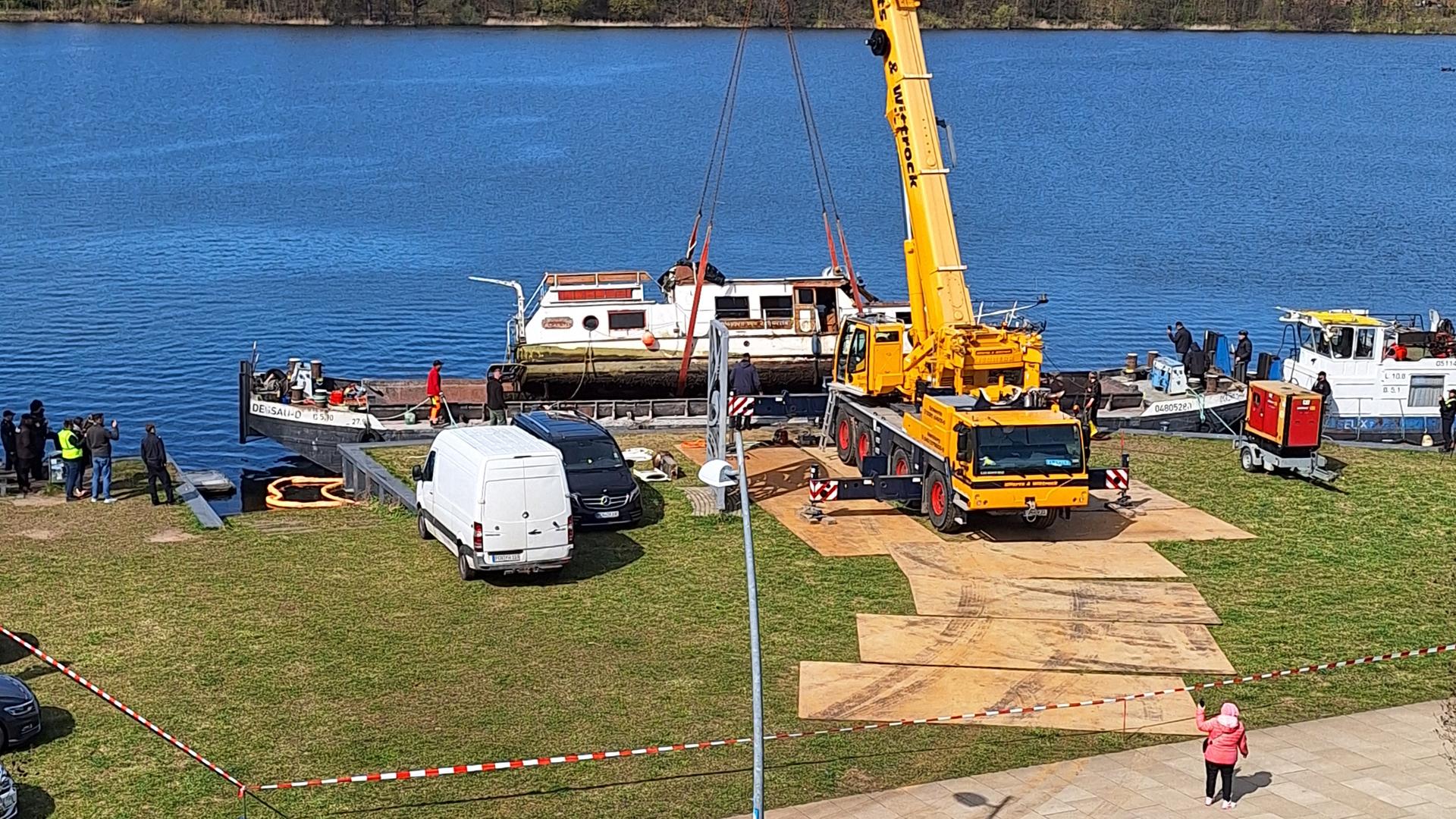 Mit einem Kran wird das havarierte Hausboot aus dem Schweriner Ziegelsee geborgen. | Christina Walther
