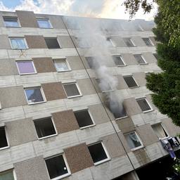 Rauch quillt aus dem geöffneten Fenster einer Wohnung.