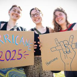 Festivalbesucherinnen Amelie (l-r), Amelie und Fenja stehen auf dem Gelände vom Hurricane Festival und halten selbstgemalte Pappschilder in die Kamera.