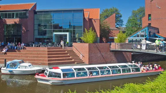 Manche Schiffsrundfahrten führen auch an der Kunsthalle vorbei. | Karlheinz Krämer, Emden, Karlheinz Krämer Außenansicht der Kunsthalle Emden, im Vordergrund ein Rundfahrt-Schiff