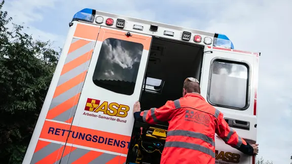 Ein Rettungssanitäter des Arbeiter-Samariter-Bund (ASB) schließt die Ladetüren an einem Rettungswagen.