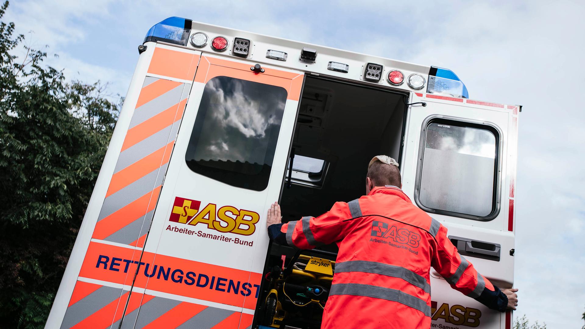 Ein Rettungssanitäter des Arbeiter-Samariter-Bund (ASB) schließt die Ladetüren an einem Rettungswagen. | NDR, Julius Matuschik