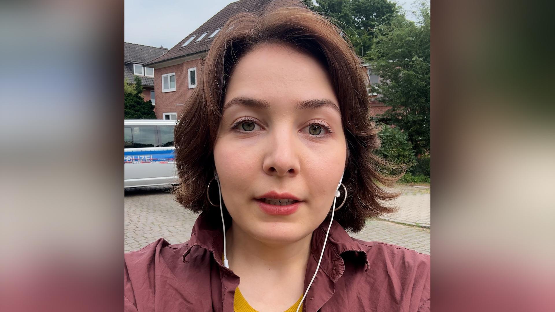 NDR Reporterin Lisa Göllert spricht mit Kopfhörern in ihr Smartphone. | NDR