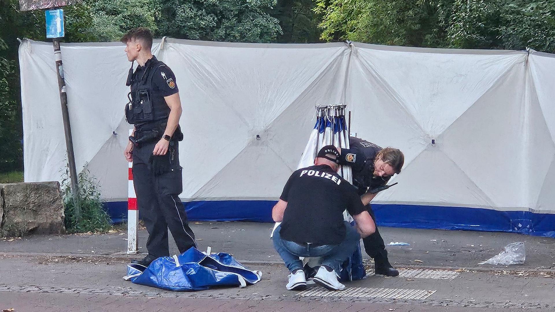 Polizisten stellen nach einer tödlichen Auseinandersetzung Sichtschutze auf. | dpa-Bildfunk, Dierk Rohdenburg/Mediengruppe Kreiszeitung