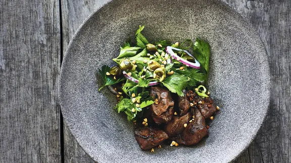 Ochsenherz mit Petersiliensalat auf einem Teller angerichtet.