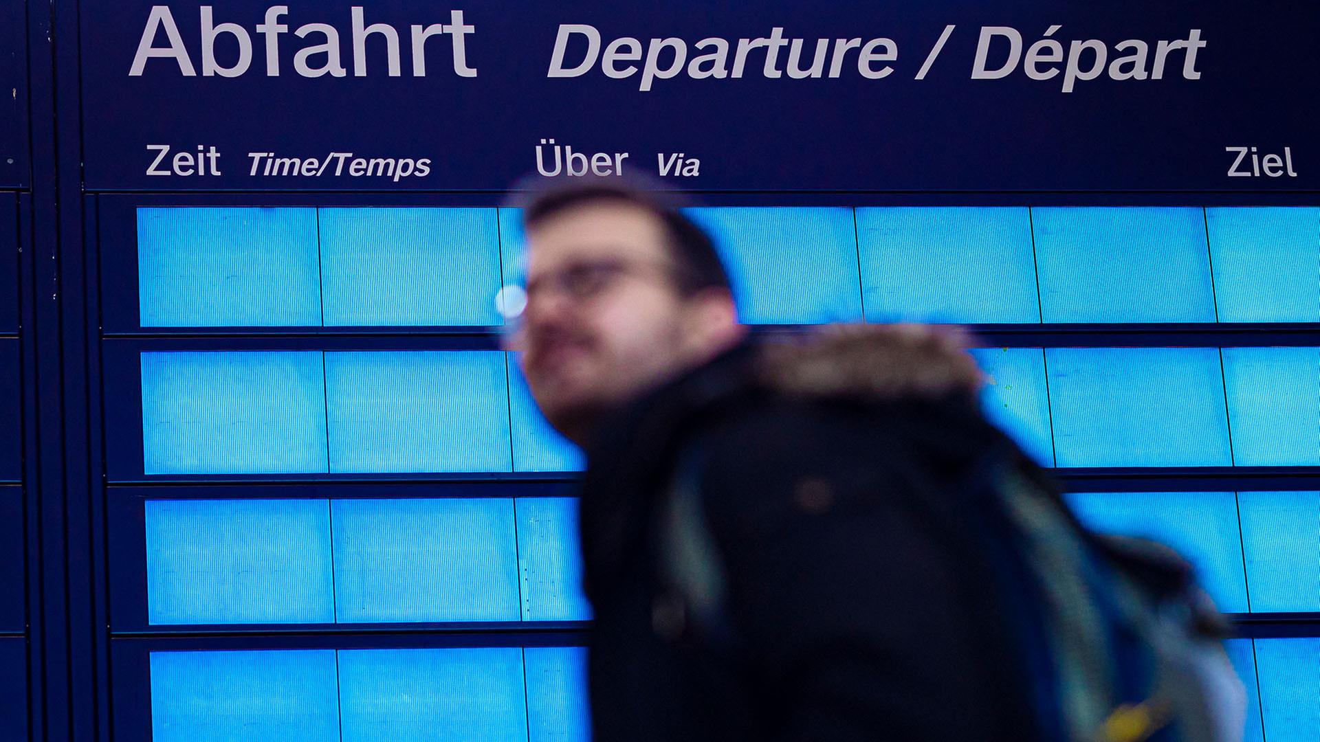 Ein Reisender geht an einer leeren Anzeigetafel im Hauptbahnhof Hannover vorbei. | dpa, Moritz Frankenberg