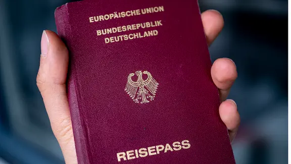 Ein Deutscher Reisepass in der Hand einer Frau.