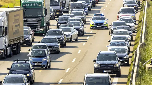 Ein Polizeiwagen fährt auf der Autobahn durch eine Rettungsgasse.