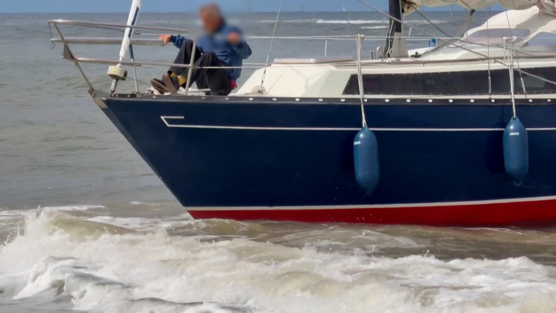 Ein Segeler sitzt mit seinem Boot bei hohem Wellengang am Strand von Norderney fest. | NonstopNews