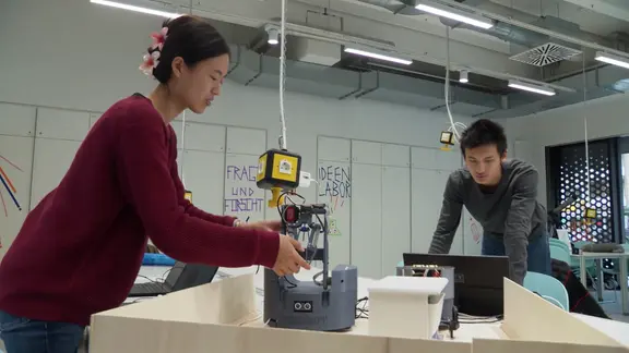 Eva und David Shi aus Hamburg zeigen einen Roboter, den die beiden entwickelt haben.