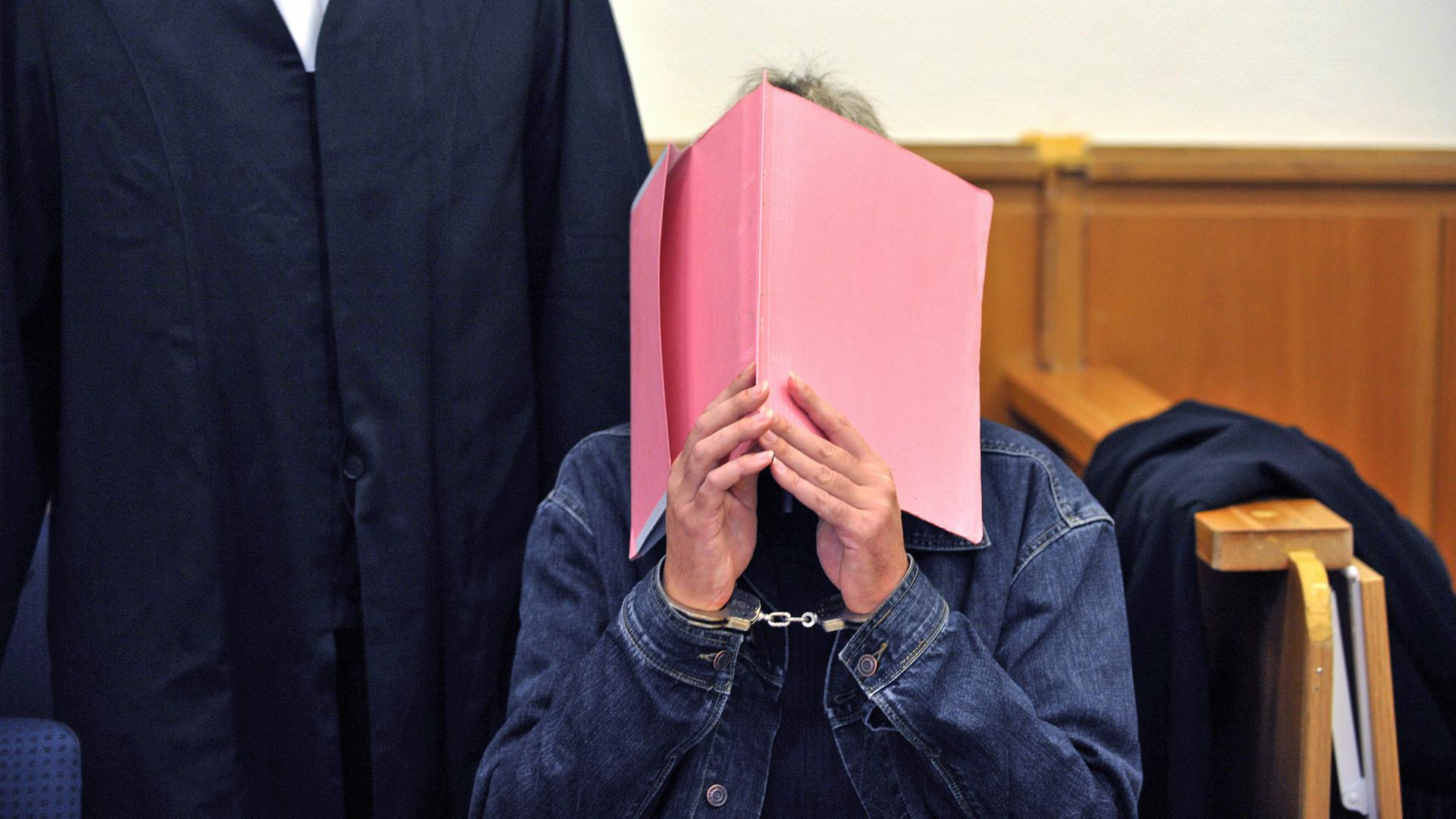Der Angeklagte Martin N. verdeckt sein Gesicht mit einer Aktenmappe. | picture alliance / dpa, Carmen Jaspersen
