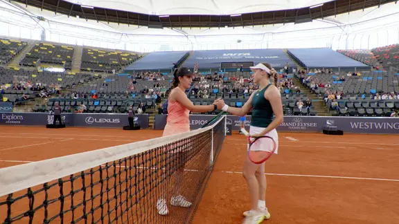 Zwei Tennisspielerinnen geben sich die Hand.
