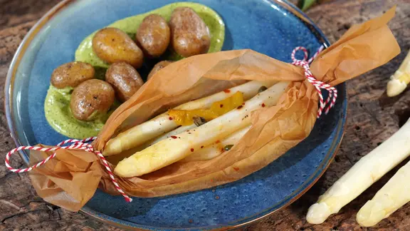 Spargel-Päckchen mit Bärlauch-Hollandaise und Drillingen auf einem Teller serviert
