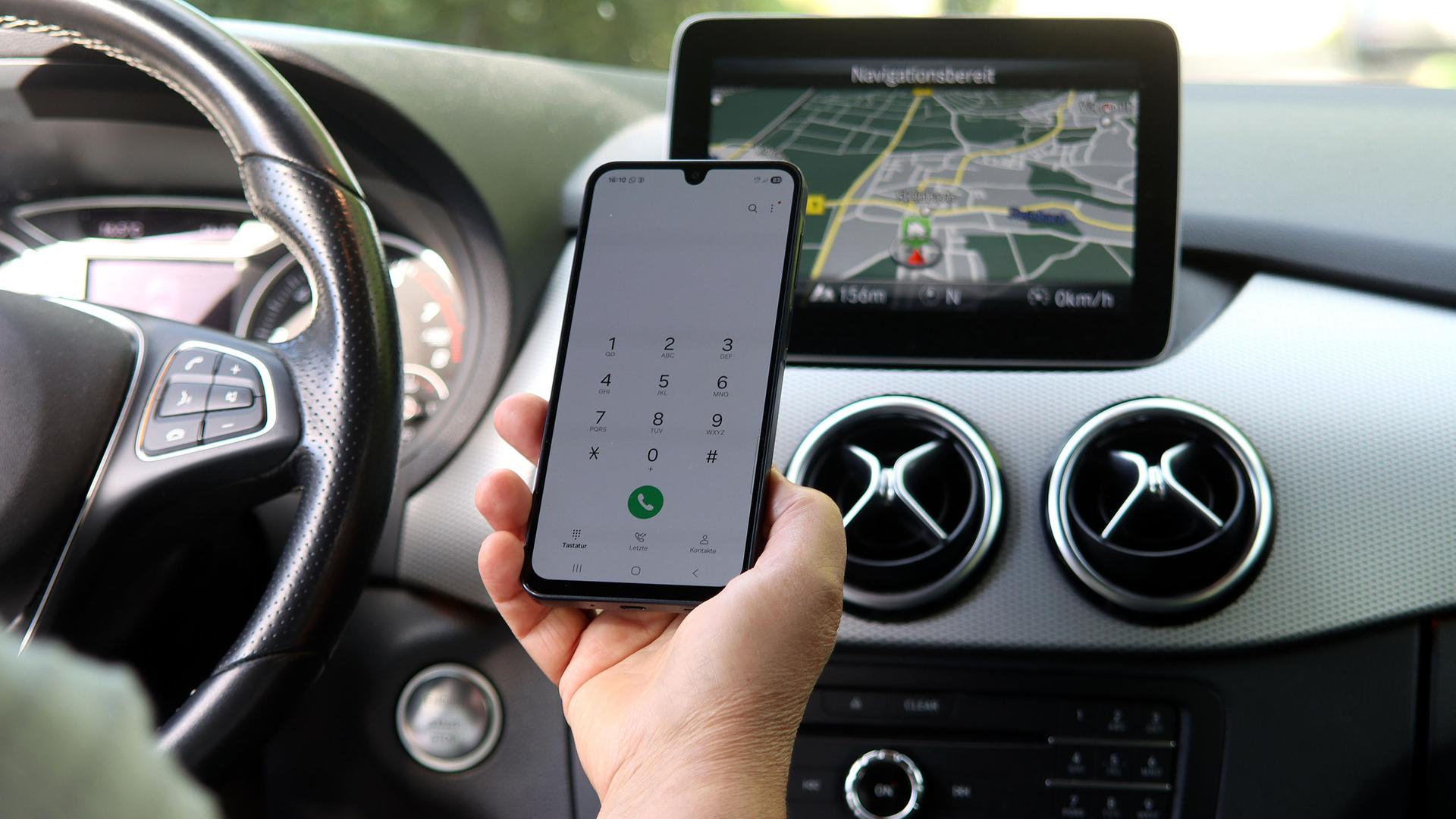 Ein Handy wird am Steuer benutzt. | picture alliance / Shotshop | Rebmann