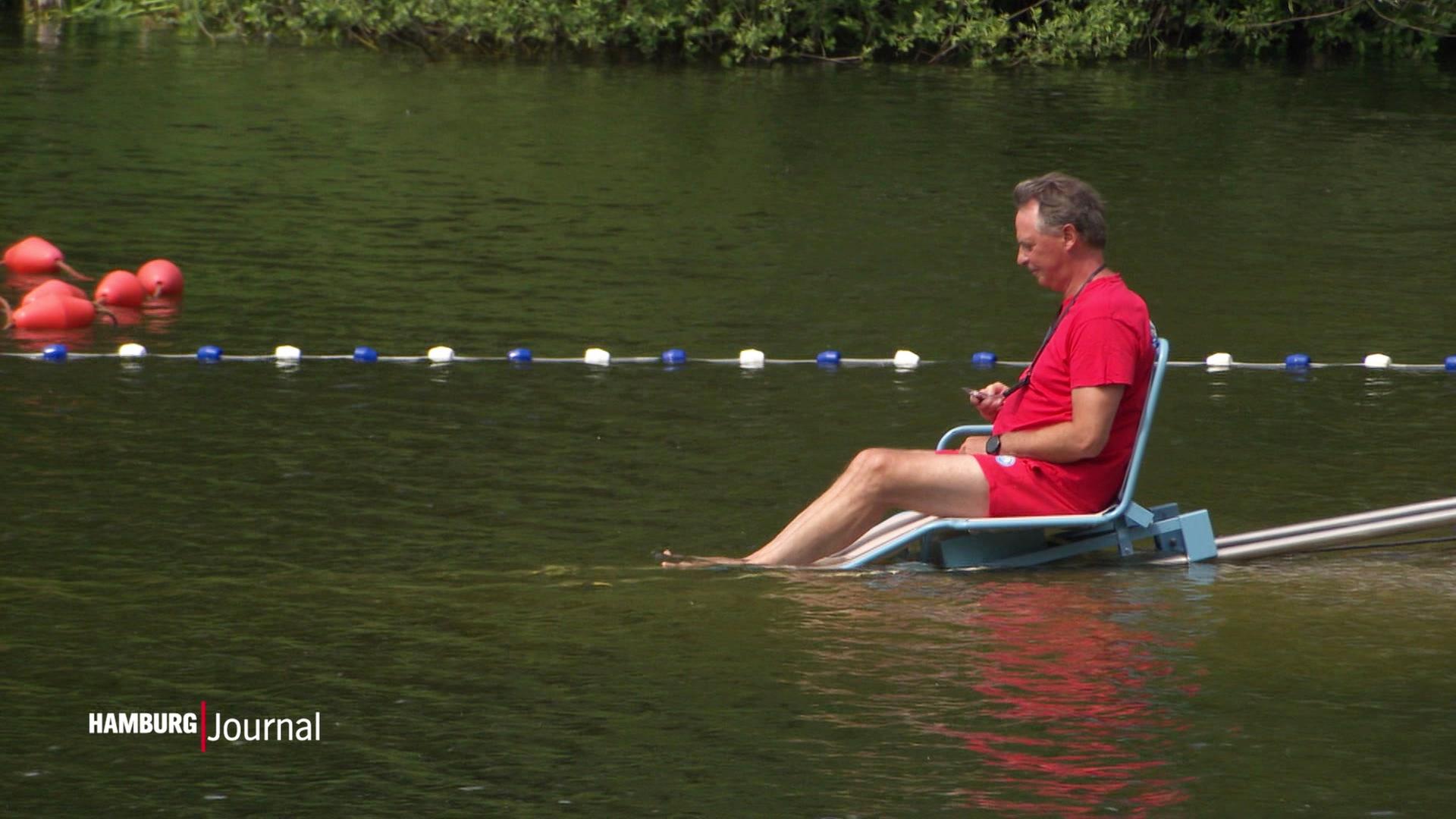 Ein Mann fährt mit Hilfe eines Schienenlifts ins Wasser.  | Screenshot