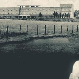 Historische Aufnahme eines Gebäudes und die Bilder zweier Kinder (Mädchen und Junge) davor montiert.