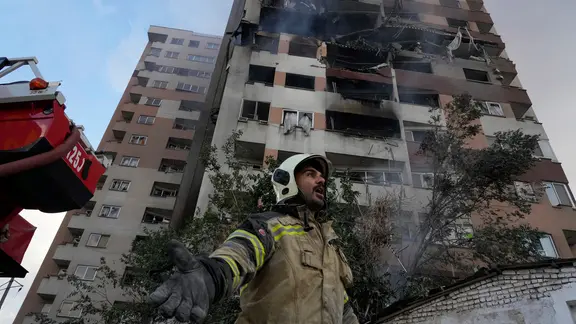 Ein Feuerwehrmann ist am Ort einer Explosion in einer Wohnanlage in Teheran im Einsatz.