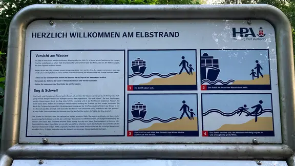 Ein Warnschild warnt am Elbufer davor, zu nah ans Wasser zu gehen.