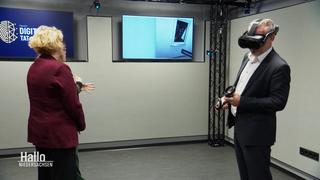 EIn Mann bedient mit einer VR-Brille eine digitale Anwendung.