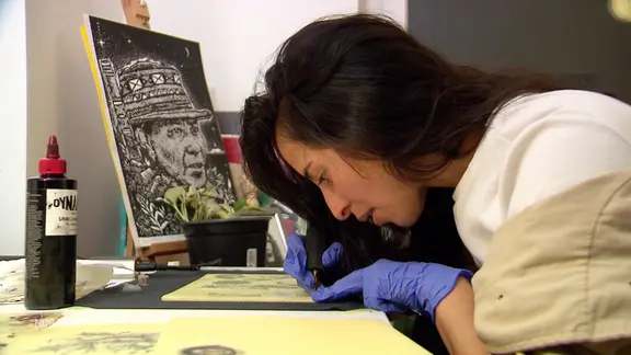 Eine junge Frau sitzt an einem Schreibtisch.