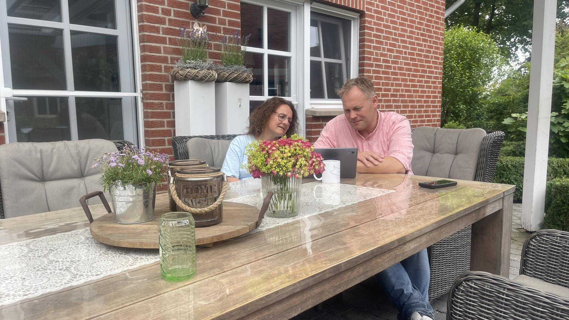 Maria und Christian Meinering sitzen auf der Terrasse und schauen auf ein Tablet | NDR, Ruth Hunfeld
