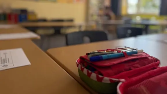 Eine Federtasche auf einem Schultisch in einem Klassenraum
