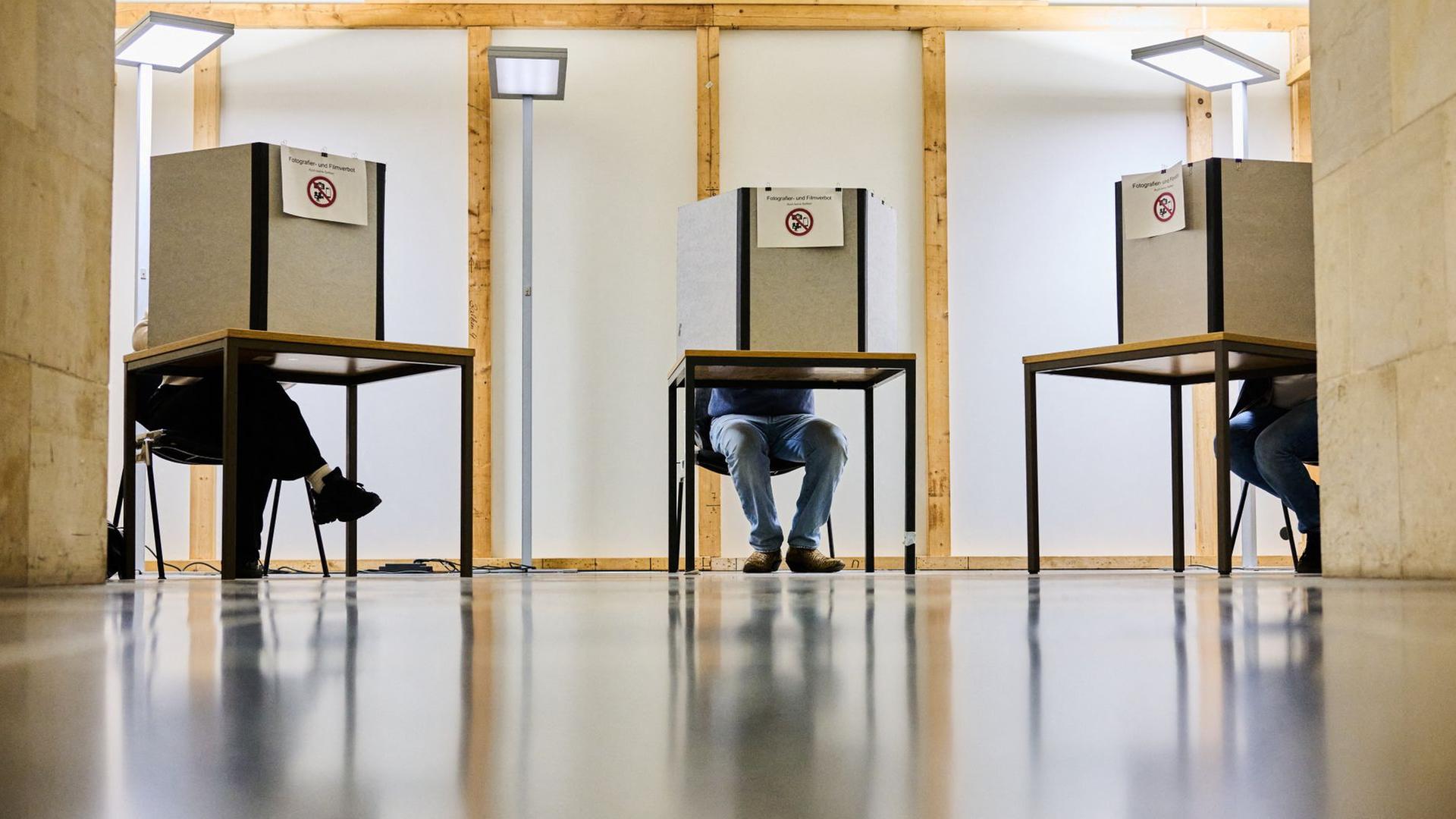 Wähler geben in Wahlkabinen ihre Stimmen für die Kommunalwahl ab.  | dpa-Bildfunk, Julian Stratenschulte
