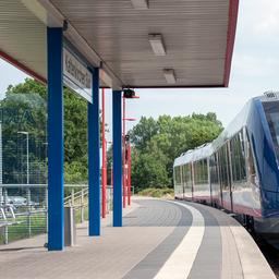 Ein Zug des Eisenbahnunternehmens AKN fährt an einer Haltestelle ein. 