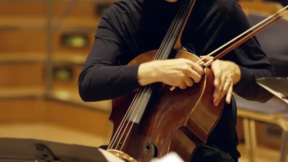 Screenshot: Hände klopfen an ein Cello