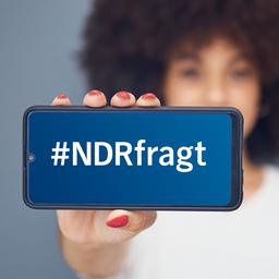 Eine Frau hält ein Smarthphone in die Kamera, auf dem Display steht "#NDRfragt"