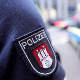 Ein Polizist steht vor einem Einsatzfahrzeug der Polizei.