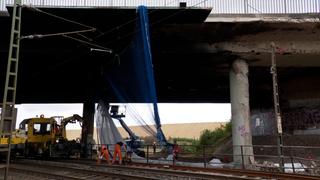 Arbeiter unter einer Brücke, die durch einen Lkw-Brand beschädigt wurden.