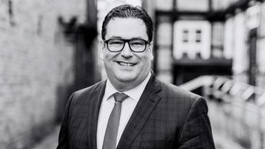 Ein schwarz-weiß Foto zeigt den verstorbenen Landrat Tobias Heilmann.