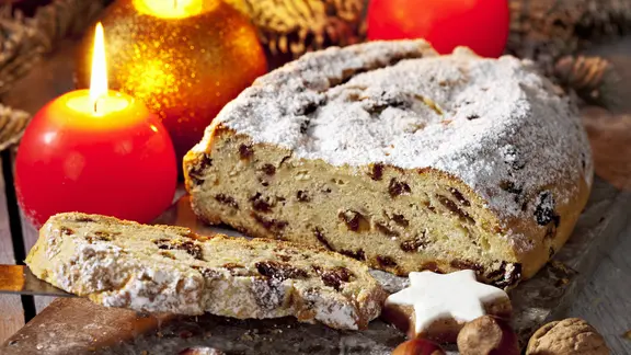 Ein angeschnittener Christstollen und weihnachtliche Kerzen | Fotolia, tunedin Ein angeschnittener Christstollen und weihnachtliche Kerzen
